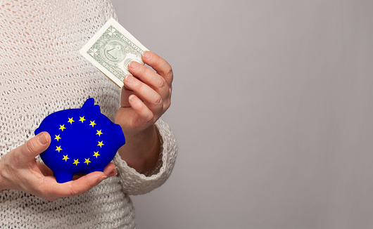 Flag of Europen Union on money bank in EU woman hands. Dotations, pension fund, poverty, wealth, retirement concept