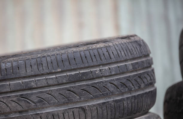 Heap of black worn-out car tires, waiting to be recycled in the circular economy.\nClose up and full frame image. Isolated on white.