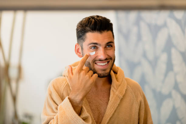 istock Man smearing cream on face 1460483449