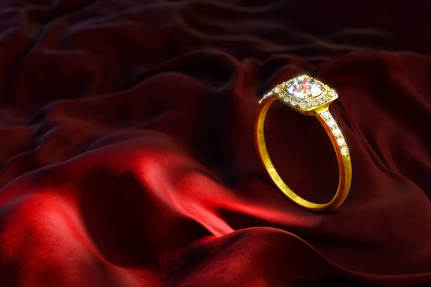 3D rendering of a gold and diamond ring on red velvet.