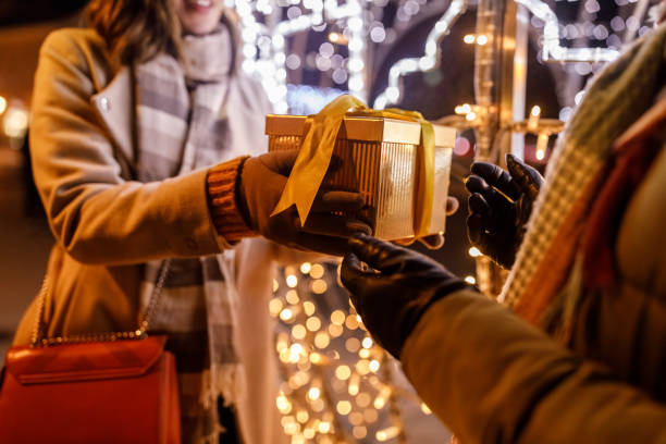 istock Caring young woman surprising her girlfriend with a Christmas gift box 1460489657