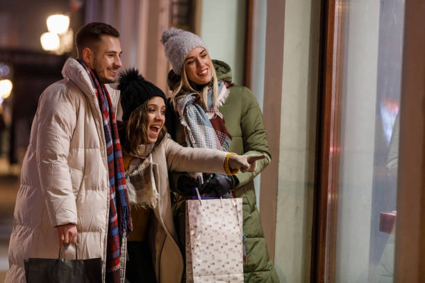 istock Three joyful friends window shopping during Christmas holidays 1460490710