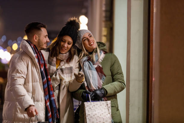 istock Three joyful friends window shopping during Christmas holidays 1460490715