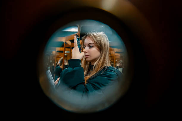 istock Girl using phone behind the door peephole 1460492789