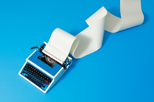 Blue typewriter of the 80s with an endless paper roll