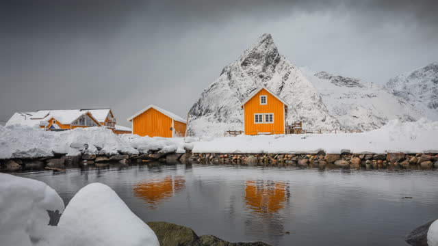 Fisherman cabin, rorbu and snow covered mountains in Norway