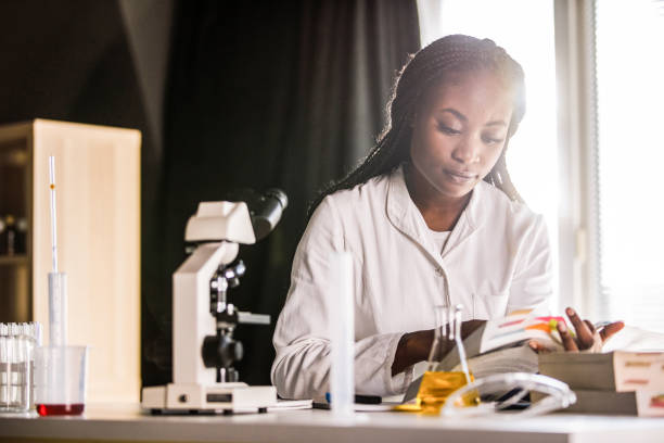 student doing internship at the laboratory, doing research and studying - medical student healthcare and medicine book education imagens e fotografias de stock