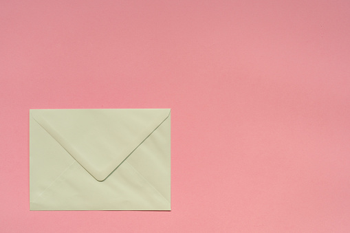 Green paper envelope on pink background