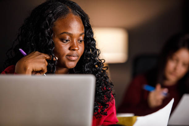 istock Young businesswoman analyzing a document and using laptop at her desk 1460502398