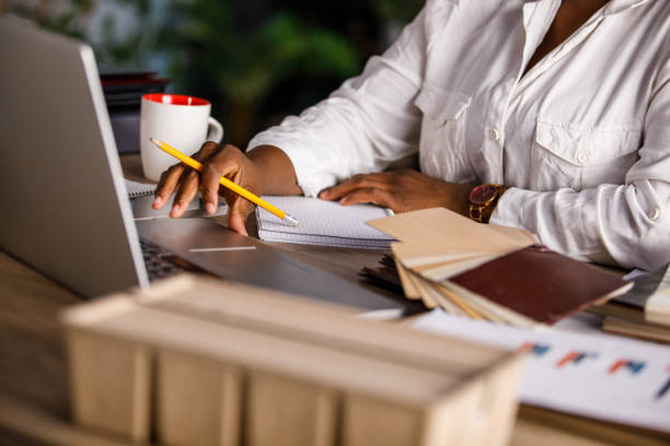 istock Female designer sitting at her desk, writing notes and brainstorming ideas while working on a project 1460502548