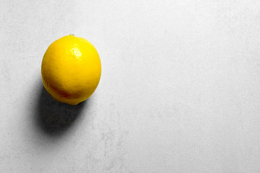 Fresh lemon on white table. Copy space. Horizontal orientation. No people.