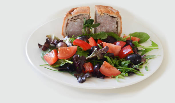 Pork Pie and green salad with white background stock photo