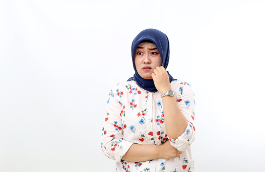 Scared asian muslim woman standing with fear face expression. Isolated on white background