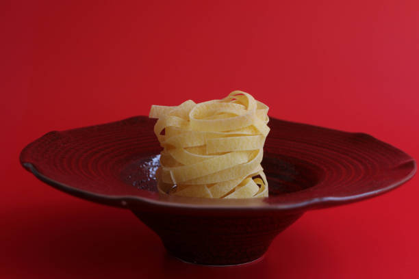 Close up Italian Noodle  Dried Fettuccine on red Background