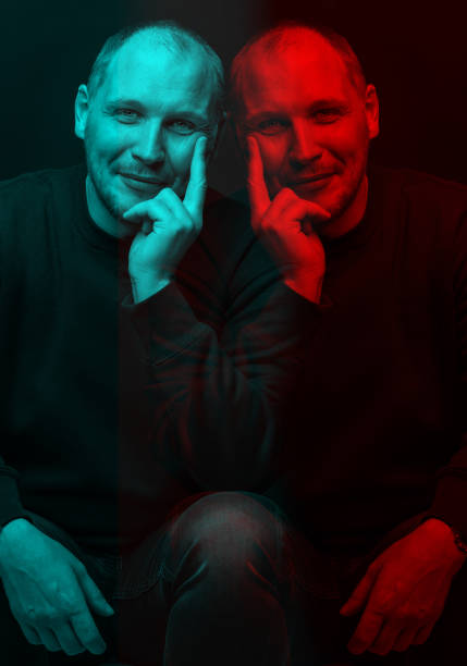 Lifestyle concept. Studio portrait of happy man with sweatshirt looking at camera with smile and holding one hand on cheek. Red and blue color split effect style. 3D glitch virtual reality effect