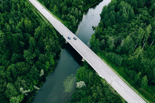 Aerial view of road over the blue river and green woods in Finland stock photo