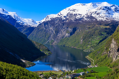 Geiranger is a village in western Norway, at the head of Geirangerfjord. The Norwegian Fjord Center has multimedia on the history of the region and its inhabitants. Part of the steep Trollstigen mountain road weaves through the village, connecting to Flydalsjuvet lookout, which has views over the fjord. The fjord’s waterfalls, including the Seven Sisters, the Suitor and the Bridal Veil, are visible by boat.