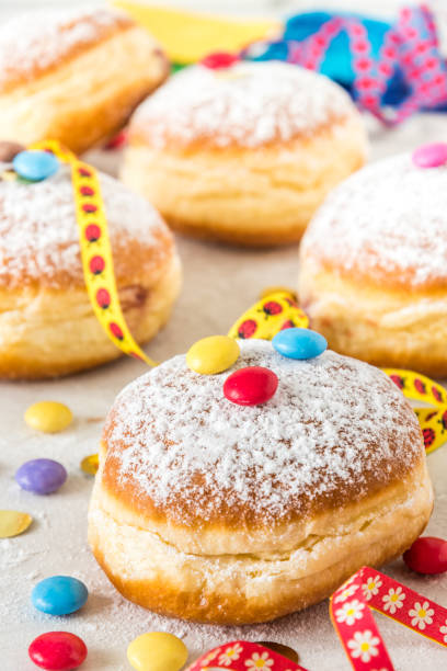 istock Carnival powdered sugar raised donuts with paper streamers, confetti and chocolate beans, vertical 1460521143