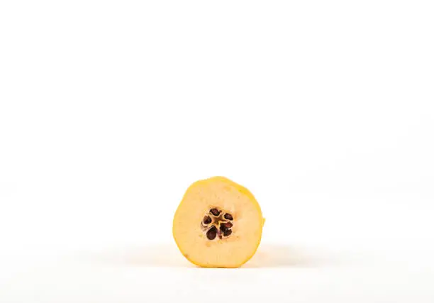 Photo of Half of quince with seeds appear on white background.