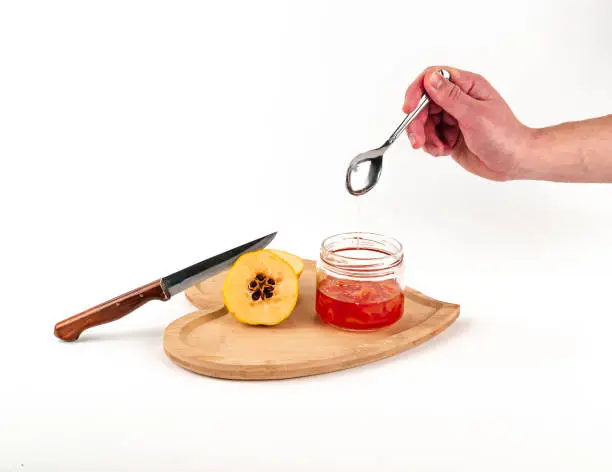 Photo of Ripe quince and jam on white background isolated. Ripe clear glass of jar full depth of field.