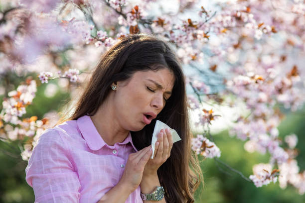 istock Girl sneezing in front of blooming tree in spring 1460528545