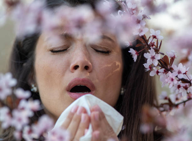 istock Girl sneezing in front of blooming tree in spring 1460528563