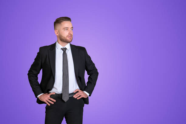 Portrait of businessman in glasses correcting tie isolated on grey