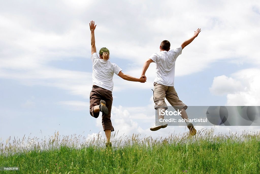 Heureux jeune couple en train de sauter - Photo de Activité libre de droits