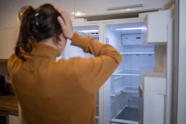 Empty fridge Woman and an empty fridge fridge problem stock pictures, royalty-free photos & images