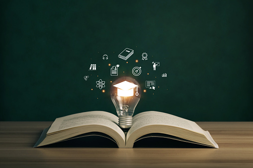 E-learning graduate certificate program concept. lightbulb on the book with graduation hat, and education icons. Internet education course degree, Idea of learning online class.Webinar Online Courses