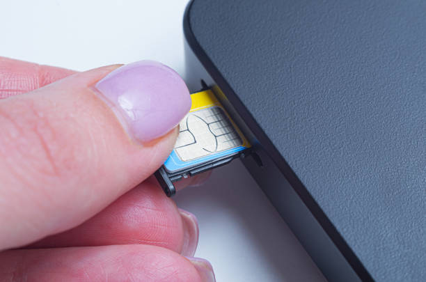 istock Woman inserting sim card into portable mobile wifi router. 1460536084