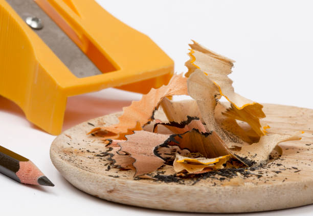 Close-up of a pencil and a sharpener with pencil shavings