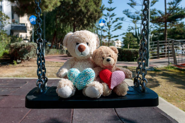 istock Two teddy bears with hearts on the swing 1460546049