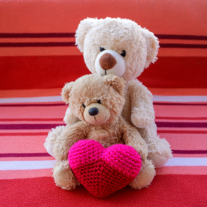 Two teddy bears with red crochet heart