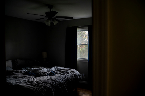 Unmade Messy Gray Bed in Small Bedroom in Afternoon in Saint Paul, Minnesota, United States