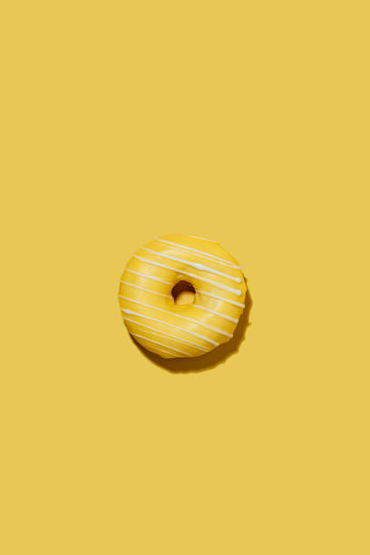 istock lemon doughnut in yellow glaze on a yellow background. pattern. 1460547485