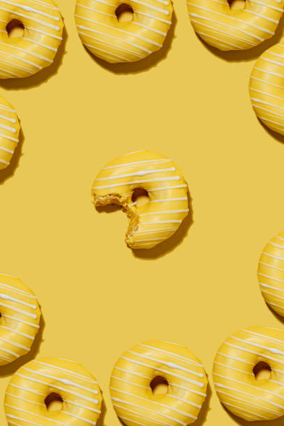 istock lemon doughnut in yellow glaze on a yellow background. pattern. 1460547501