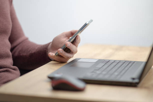 istock Close up of a man working on laptop and using smartphone. 1460551775