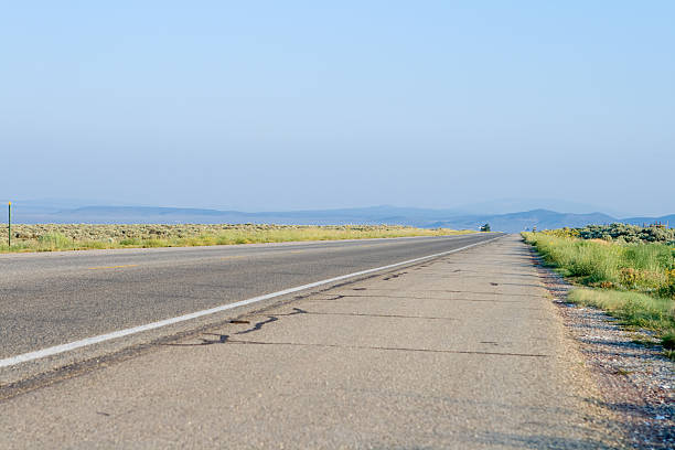 flatfront und gerade highway von taos, new mexico, usa - flat vanishing point distant mid distance stock-fotos und bilder