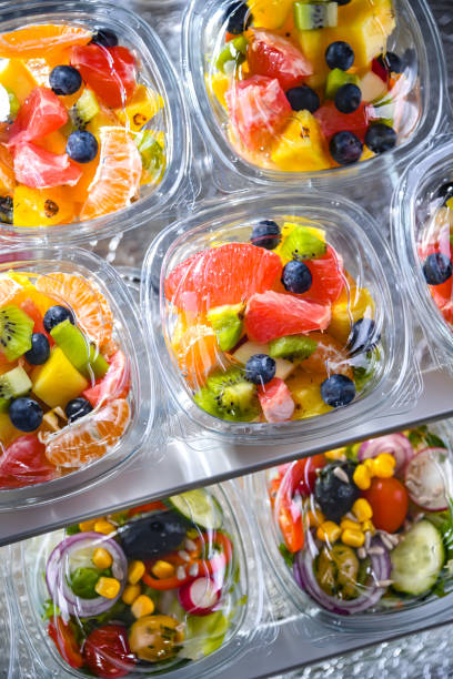 boxes with pre-packaged fruit salads in a commercial fridge - packaged food imagens e fotografias de stock