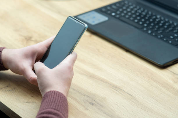 istock Close up of a man working on laptop and using smartphone. 1460553871