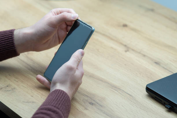 istock Man hands holding smartphone. Man using smartphone and pointing on the screen with one finger 1460553960