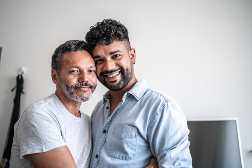 Portrait of a gay couple face to face in living room at home