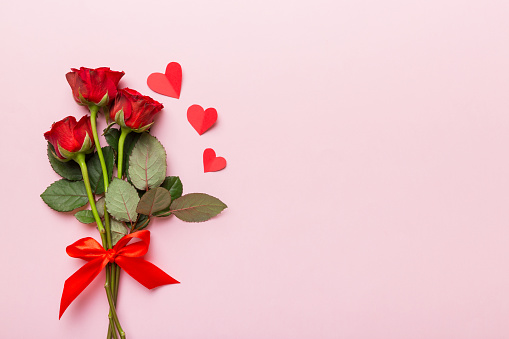 Valentine day composition with rose flower and red heart on table. Top view, flat lay, copy space Holiday concept.