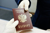 Hands passing Russian passport