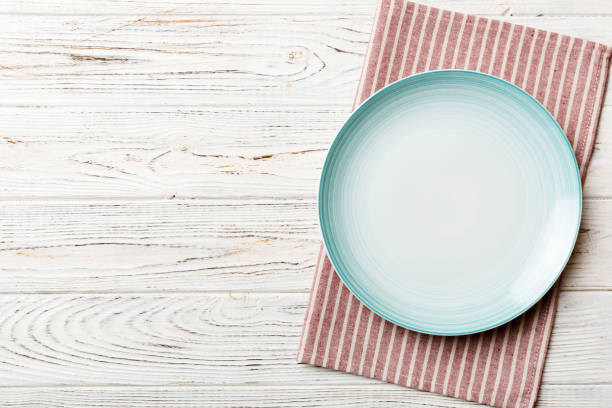 istock Top view on colored background empty round blue plate on tablecloth for food. Empty dish on napkin with space for your design 1460557064