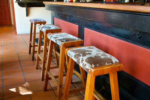 Row of bar stools with cow skin pattern seat