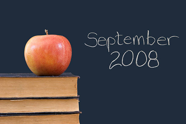 September 2008 written on blackboard with apple, books