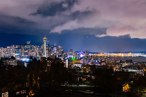Seattle Skyline Washington State at night with clouds visible over the city.
