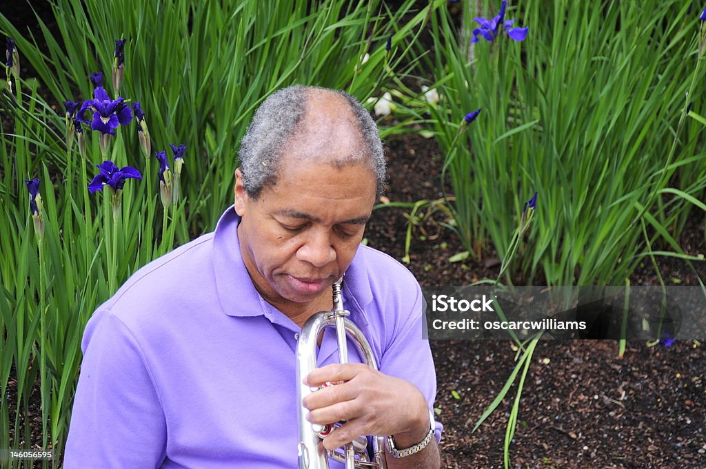Jazz Musician Jazz musician relaxing in a flower garden. Adult Stock Photo